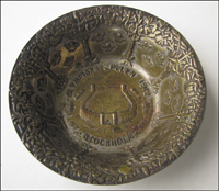 Versilberte Schale mit dem Olympia-Stadion und der Inschrift "Olympiska Spelen 1912 Stockholm". Durchmesser: 11 cm, Hhe: 3 cm.