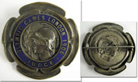 Offizielles Teilnehmerabzeichen fr die Olympischen Spiele 1908 in London mit der Aufschrift "Olympic Games London 1908 Judge" (Jury).  Bronze, versilbert, blau emailliert, Hersteller: "Vaughton,Birmingham", 5,7 cm.