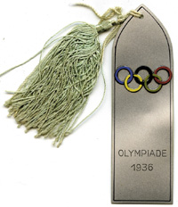 Olympiade 1936. Aluminium Streifen mit aufgesetztem emaillierten Olympischen Ringen. Mit Seidenbommel. 20x3,4cm.