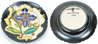 Kleiner, handbemalter, farbiger Keramikwandteller mit floralem Motiv. Rckseite beschriftet "Olympiade 1928" 16 cm.