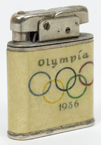 Feuerzeug mit weiem Kunststoffdekor mit farbigen Olympischen Ringen und Schriftzug Olympiad 1936. Fr Benzingebrauch. 4,5x4x1 cm.