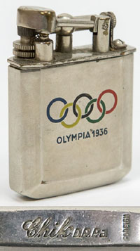 Verchromtes Feuerzeug mit farbigen emaillierten Olympischen Ringen und der Inschrift "Olympiade 1936". Marke: "Chik" und der Punze "Foreign".  4,5x3,7x1,2 cm.