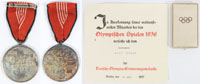 Deutsche Olympia-Erinnerungsmedaille, verliehen fr verdienstvolle Mitarbeit bei den Olympischen Spielen 1936. Am Originalband. Bronze, versilbert, gestiftet 1936. Durchmesser der Medaille 3,6 cm. In Originaletui mit Olympischen Ringen. Dabei: Urkunde fr