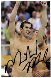 Farbfoto mit Originalsignatur von Michael Phelps (USA). Sportsuperstar. Er gilt als der vielseitigste Schwimmer der Gegenwart und ist mit 28 olympischen Medaillen, davon 23-mal Gold, der mit weitem Abstand erfolgreichste Olympionike der Geschichte. Gibt ka